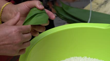一位老人正在做中国传统食品粽子特写